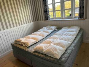 una fila de almohadas en una cama en una habitación en Luxury Cottage Only 250m From Beach And Forest en Rude