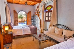 - un salon avec un canapé, un lit et une table dans l'établissement Riad Dar Etto, à Essaouira