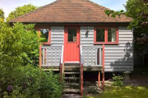 The Granary at Palm Tree House in S.E. Kent في Lyminge: منزل صغير مع باب احمر
