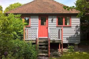 een klein huis met een rode deur bij The Granary at Palm Tree House in S.E. Kent in Lyminge