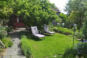 twee stoelen en een tafel in de tuin bij The Granary at Palm Tree House in S.E. Kent in Lyminge