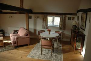 een woonkamer met een tafel en stoelen bij The Granary at Palm Tree House in S.E. Kent in Lyminge