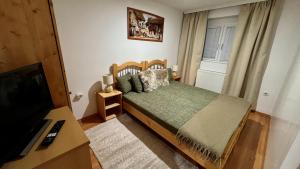 a bedroom with a large bed and a television at Naposdomb Vendégház in Miskolc