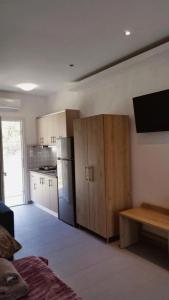 a room with a kitchen with a refrigerator and a tv at CASA QUERCU in Sykia Chalkidikis