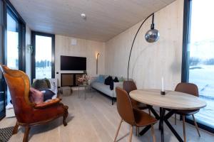 sala de estar con mesa, sillas y sofá en The Oceanfront Private northern lights villa. en Reynivellir