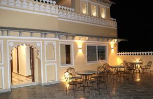 a group of tables and chairs on a patio at night at Hotel Fort Padmawati in Pratāpgarh