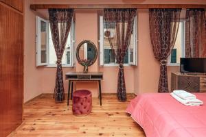 a bedroom with a bed and a mirror and a table at Venetian Reale Apartment in Corfu Town