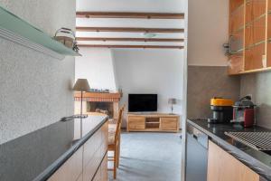 a kitchen with a counter and a television in a room at Pic-Chaussy B14 in Les Mosses