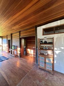 sala de estar con techo de madera y mesa en Paraíso da serra en São Francisco Xavier