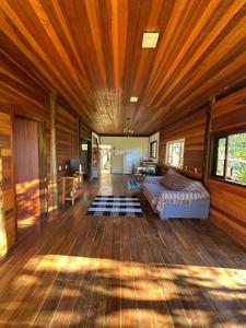 Paraíso da serra في ساو فرنسيسكو كزافييه: غرفة كبيرة بسرير وسقف خشبي