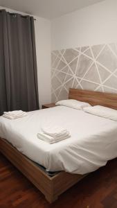 a bed with two white towels on top of it at Casa n 1 con parcheggio privato e colonnina ricarica in Livorno