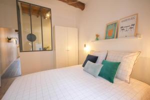 a bedroom with a white bed with four pillows at Old Town apartment with view in Lille