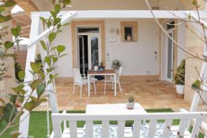 a patio with a table and chairs in a house at Cesarina Suite Apartment in Alessano