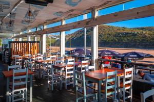 un restaurante con mesas y sillas con vistas al océano en House beach in Lizandro by Ericeira Property en Carvoeira