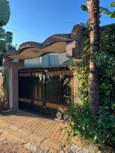 una casa con una puerta y una palmera en Tropical Oasis Retreat, en Kisubi