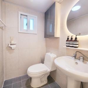 een badkamer met een wit toilet en een wastafel bij Daol Stay in Seoul