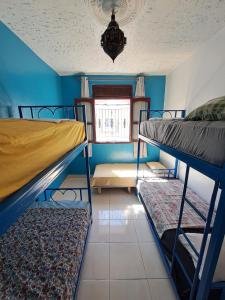 a room with three bunk beds and a window at Moroccan Family House in Agadir