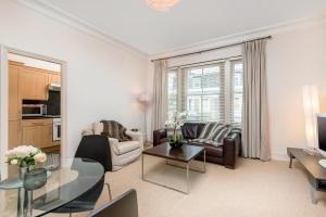 a living room with a couch and a table at Spacious, Calm One Bedroom in London