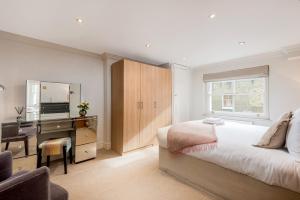 a bedroom with a bed and a desk with a computer at Spacious, Calm One Bedroom in London