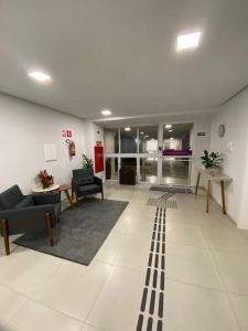 a living room with couches and chairs in a building at Kitnet alto padrão sem taxa de limpeza in Cachoeira do Sul
