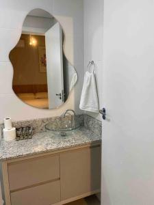 a bathroom with a sink and a mirror at Kitnet alto padrão sem taxa de limpeza in Cachoeira do Sul