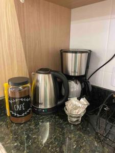 a kitchen counter with a coffee pot and a coffeeicer at Kitnet alto padrão sem taxa de limpeza in Cachoeira do Sul