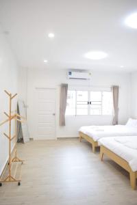 um quarto branco com 3 camas e uma janela em Rest24 Betong em Betong
