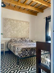 Un dormitorio con una cama y una mesa. en Ilusiones del Mar, en El Palmar