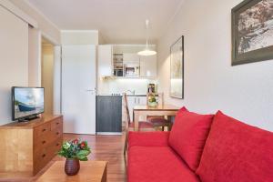 sala de estar con sofá rojo y cocina en Fewo 300, Seepark Sellin, en Ostseebad Sellin