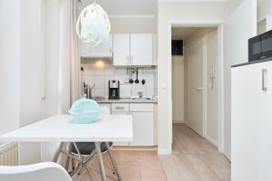 a kitchen with white cabinets and a blue bowl on a table at Seepark Sellin FeWo AG Whg 306 in Ostseebad Sellin