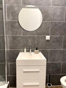 een badkamer met een witte wastafel en een spiegel bij The blue VIEcation apartment in Wenen