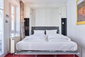 Schlafzimmer mit einem Bett mit weißer Bettwäsche und Kissen in der Unterkunft Seepark Sellin FeWo AG Whg 321 in Ostseebad Sellin