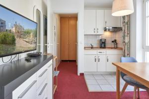 eine Küche und ein Esszimmer mit einem Flachbild-TV in der Unterkunft Seepark Sellin FeWo AG Whg 321 in Ostseebad Sellin