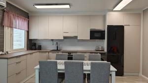 a kitchen with white cabinets and a table and chairs at Apartment in Säkylä centrum in Säkylä