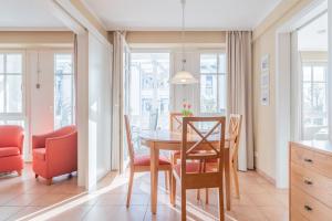 eine Küche und ein Esszimmer mit Tisch und Stühlen in der Unterkunft Seepark Sellin FeWo AG Whg 314 in Ostseebad Sellin