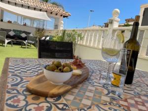 einen Tisch mit einer Schale Obst und einer Flasche Wein in der Unterkunft Pinet beach 86 in Elche