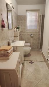 bagno bianco con lavandino e servizi igienici di Apartments Tomišić a Capodistria