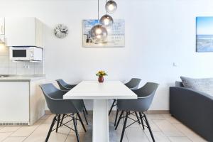 uma cozinha com uma mesa branca e cadeiras em Fewo 345, Seepark Sellin em Ostseebad Sellin