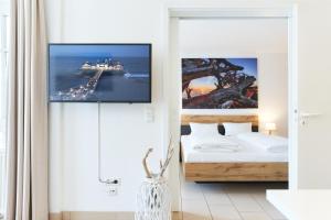 um quarto com uma cama e uma televisão na parede em Fewo 345, Seepark Sellin em Ostseebad Sellin