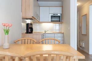 - une cuisine avec une table et des chaises en bois dans l'établissement Fewo 352, Seepark Sellin, à Sellin