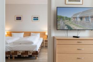 - une chambre avec un lit et une télévision à écran plat dans l'établissement Fewo 352, Seepark Sellin, à Sellin