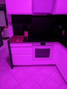 cocina con luces rosas encima de una estufa en Le Spacidulé, en Saint-Amand-les-Eaux