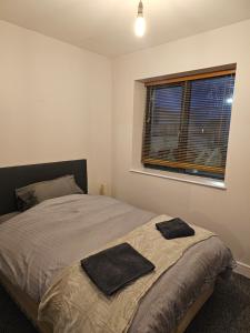 a bedroom with a bed with two towels on it at Cozy 2 Bedroom Apartment in Kilkenny