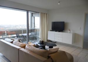 a living room with a couch and a flat screen tv at Kom tot rust in een heerlijk verblijf - Toplocatie met zonneterras! in Nieuwpoort