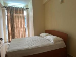 a small bedroom with a bed with a window at Nexus 25 in Colombo