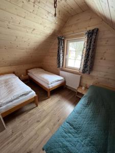 a bedroom with two beds and a window in a cabin at Domki - Zajazd Zieleńska Polana in Wisła