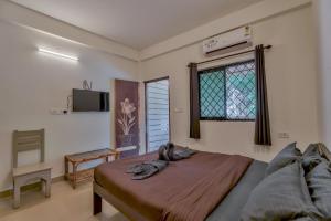 a bedroom with a bed and a tv on the wall at Rosa Bella Resort-TBV in Calangute