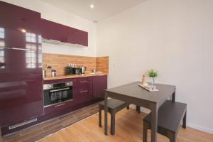 a kitchen with purple cabinets and a table at Lille Centre - Nice and functional ap. in Lille