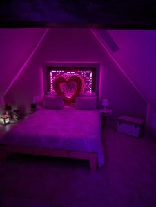 a purple bedroom with a bed with a heart sign at Le Spacidulé in Saint-Amand-les-Eaux
