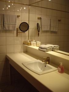 a bathroom with a sink and a mirror and towels at Hotel Pension Stadlhuber Aktivpark Kremsmünster in Kremsmünster